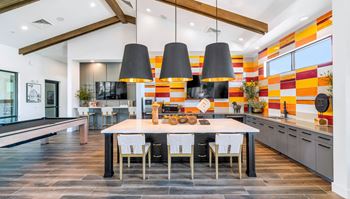 a dining room with a table and chairs in front of a kitchen with a counter at Weylyn Luxury Apartments, Arizona